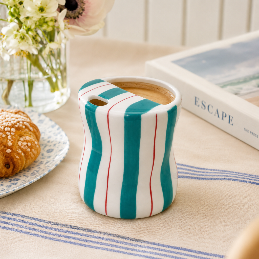 Teal striped ceramic mug with coffee styled in a bright breakfast setting