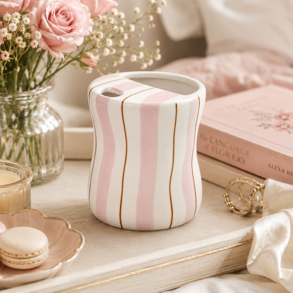Pink striped ceramic mug styled with flowers and desserts in a cozy setting
